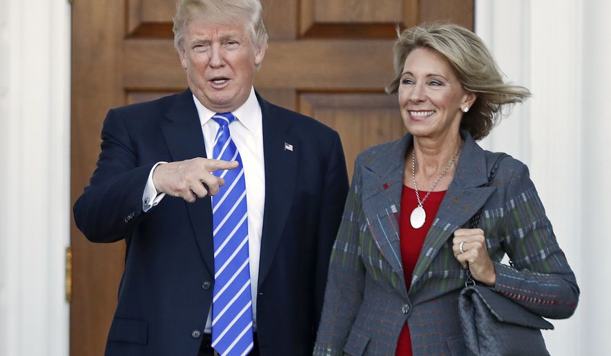 FILE – In this Nov. 19, 2016 file photo, President-elect Donald Trump, left, and Betsy DeVos, right, pose for photographs at Trump National Golf Club Bedminster&#39;s clubhouse in Bedminster, N.J. Republican Ohio Gov. John Kasich wrote a Jan. 24, 2017, letter urging confirmation of DeVos, Trump&#39;s education secretary nominee, without mentioning the significant unpaid fine owed to Ohio by a now-defunct political action committee she controlled. (AP Photo/Carolyn Kaster, File)
