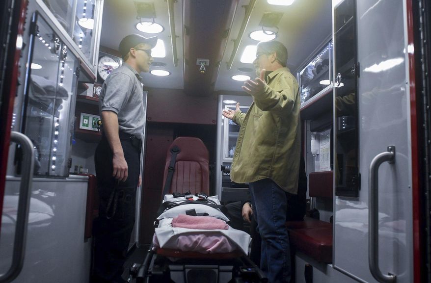 CORRECTS SOURCE TO THE REPUBLICAN-HERALD, NOT THE TIMES & TRIBUNE-Bill Malloy, right, meets with first responders on Thursday, Jan. 19, 2017 who came to the rescue after he suffered a heart attack in Valley View, Pa. Tyler Perry, left, 19, EMT student, helped to calm his wife while the others worked on him. Perry showed Malloy the ambulance that took him to the hospital. (Andy Matsko/Republican-Herald via AP)