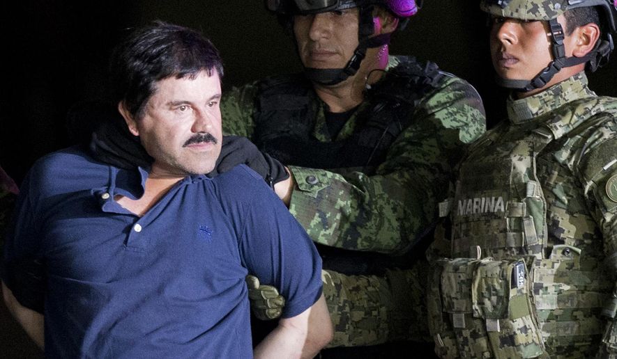 FILE - In this Jan. 8, 2016 file photo, a handcuffed Joaquin "El Chapo" Guzman is made to face the press as he is escorted to a helicopter by Mexican soldiers and marines at a federal hangar in Mexico City. Guzman is scheduled to appear in person in a federal court in New York. A judge initially ruled that Guzman would appear in court by video on Friday, Feb. 3, rather than have marshals escort him to and from a high-security Manhattan jail cell. The order was changed after his lawyers asked the judge to reconsider. (AP Photo/Eduardo Verdugo, File)
