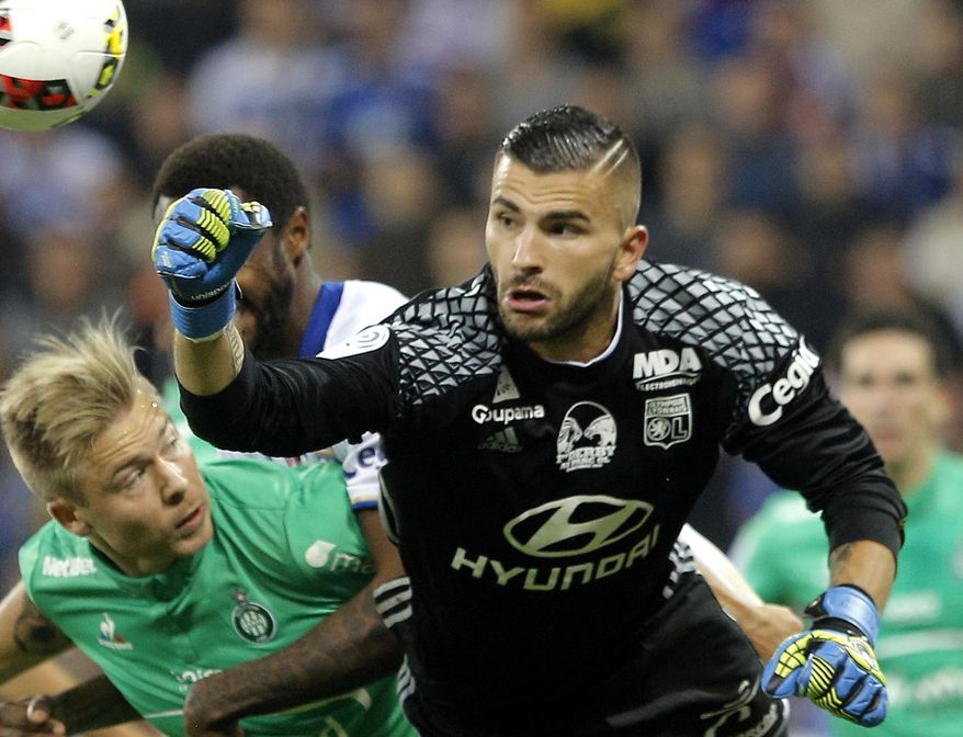 FILE - In this file photo dated Sunday, Oct. 2, 2016, Lyon&#39;s goalkeeper Anthony Lopes, right, bats the ball away during the French League One soccer match between Lyon and Saint-Etienne, in Decines, near Lyon, central France. Lopes is considered to have defamed the name of bitter rivals Saint-Etienne during a recent match, making him a marked man for upcoming match between Lyon and Saint-Etienne. (AP Photo/Laurent Cipriani, FILE)