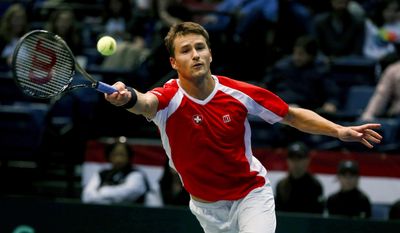 Switzerland's Marco Chiudinelli reaches to hit a shot from United States' Jack Sock during a Davis Cup tennis match Friday, Feb. 3, 2017, in Birmingham, Ala. (AP Photo/Butch Dill)