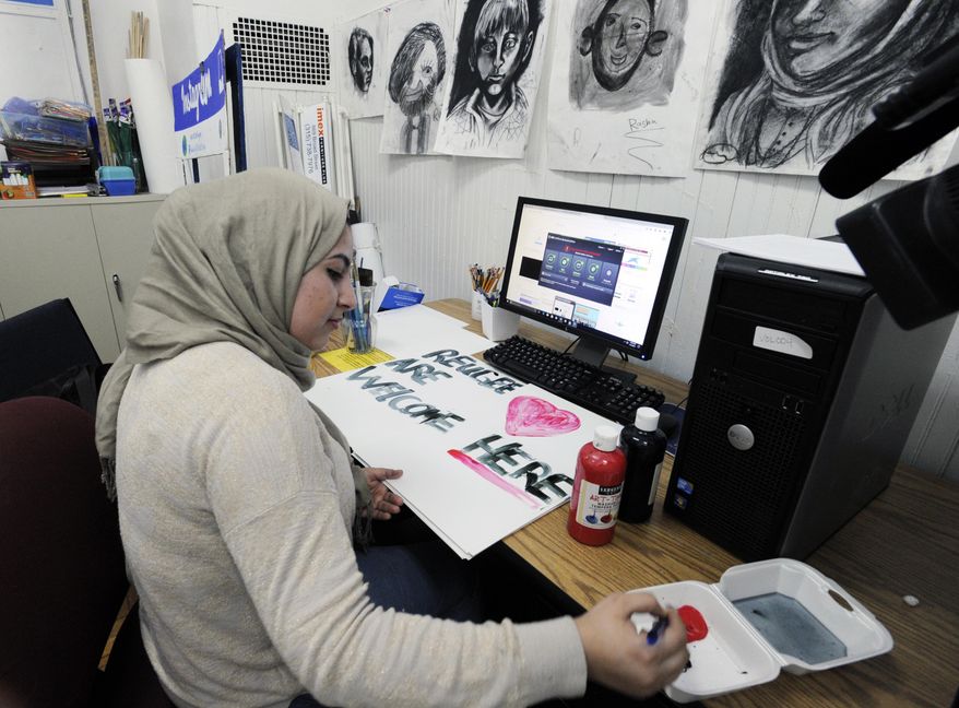 In this Jan. 31, 2017 photo, Palestinian refugee Manal Alawsaj, who was born in Iraq, works at making welcome posters at the Mohawk Valley Resource Center for Refugees in Utica, N.Y. The upstate New York city, that has gained new life from refugees, is looking at a sharp decrease in arrivals under President Donald Trump’s executive order restricting refugees and travel from Muslim countries. (AP Photo/Hans Pennink)