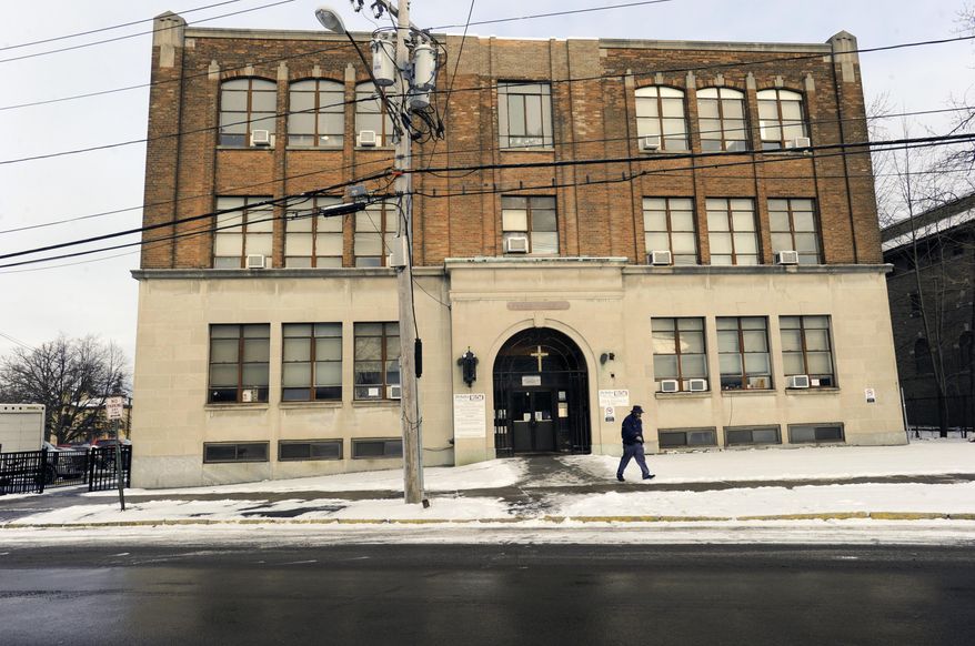 In this Jan. 31, 2017 photo, a pedestrian passes the Mohawk Valley Resource Center for Refugees building in Utica, N.Y. Utica has been a refugee "oasis" for decades. Vietnamese, Bosnians, Somalians and Burmese have each found shelter in the city that has benefited from the infusion of house-proud residents who work in hospitals, factories and their own businesses. But now President Donald Trump's executive order crimping the flow of refugees has sent a shudder through the city in upstate New York. (AP Photo/Hans Pennink)