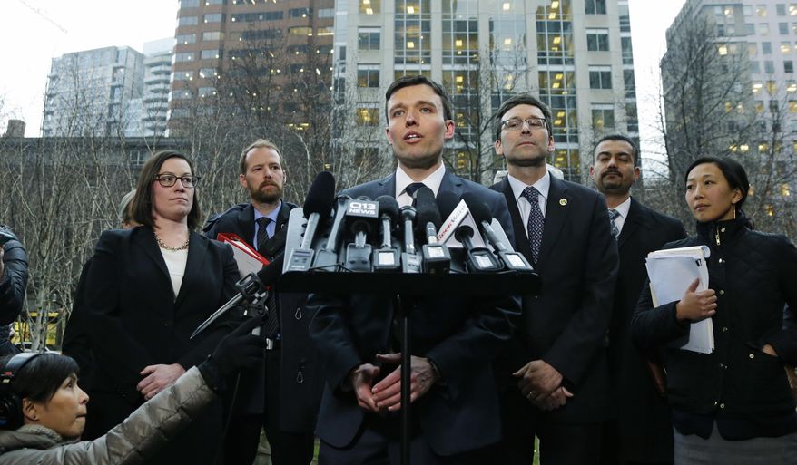 Washington state Solicitor General Noah Purcell, center, talks to reporters as Attorney General Bob Ferguson, third from right, looks on, Friday, Feb. 3, 2017, following a hearing in federal court in Seattle. A U.S. judge on Friday temporarily blocked President Donald Trump's ban on people from seven predominantly Muslim countries from entering the United States after Washington state and Minnesota urged a nationwide hold on the executive order that has launched legal battles across the country.(AP Photo/Ted S. Warren)