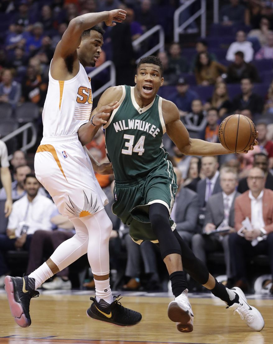 Milwaukee Bucks forward Giannis Antetokounmpo (34) drives past Phoenix Suns forward TJ Warren during the first half of an NBA basketball game, Saturday, Feb. 4, 2017, in Phoenix. (AP Photo/Matt York)