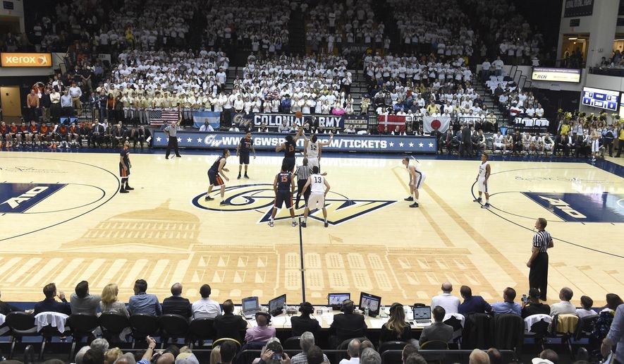 In this Nov. 16, 2015 photo provided by The George Washington University, George Washington plays Virginia in front of a sold out crowd at an NCAA college basketball game at the Charles E. Smith Center in Washington, DC. College basketball floors once had simple designs, the only flair usually the addition of color in the lane or at midcourt. Court designs have taken a creative twist over the past few years with schools adding elaborate detail. (The George Washington University via AP) **FILE**