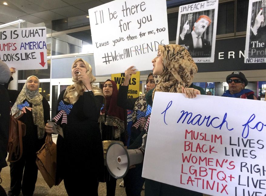 Protesters against President Trump's temporary travel ban on citizens from seven Muslim-majority nations stand in front of the Bradley Terminal at Los Angeles International Airport, Saturday, Feb. 4, 2017, in Los Angeles. (AP Photo/Reed Saxon)