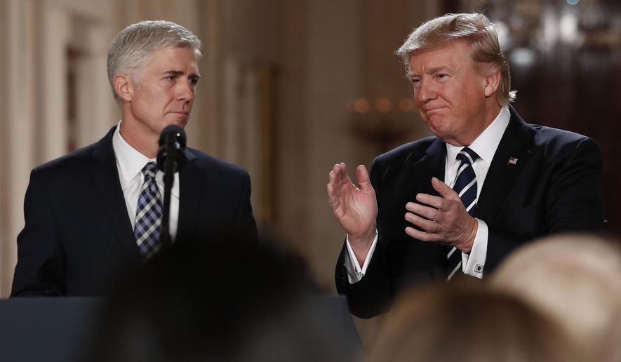 President Donald Trump applauds as he stands with Judge Neil Gorsuch in the East Room of the White House in Washington, after announcing Gorsuch as his nominee for the Supreme Court, int his Jan. 31, 2017, file photo. (AP Photo/Carolyn Kaster)