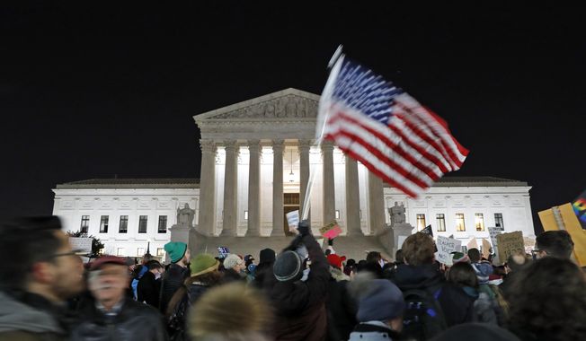 In this Jan. 30, 2017, photo, a protester waves an American flag in front of the Supreme Court during a protest about President Donald Trump&#x27;s recent executive orders in Washington. Two weeks into his presidency, Donald Trump has thrown Washington into a state of anxious uncertainty. Policy pronouncements sprout up from the White House in rapid succession. Some have far-reaching implications, most notably Trump’s temporary refugee and immigration ban, but others disappear without explanation, including planned executive actions on cybersecurity and the president’s demand for an investigation into unsubstantiated voter fraud. The day’s agenda can quickly be overtaken by presidential tweets, which often start flashing on smartphones just as the nation’s capital is waking up. (AP Photo/Alex Brandon)