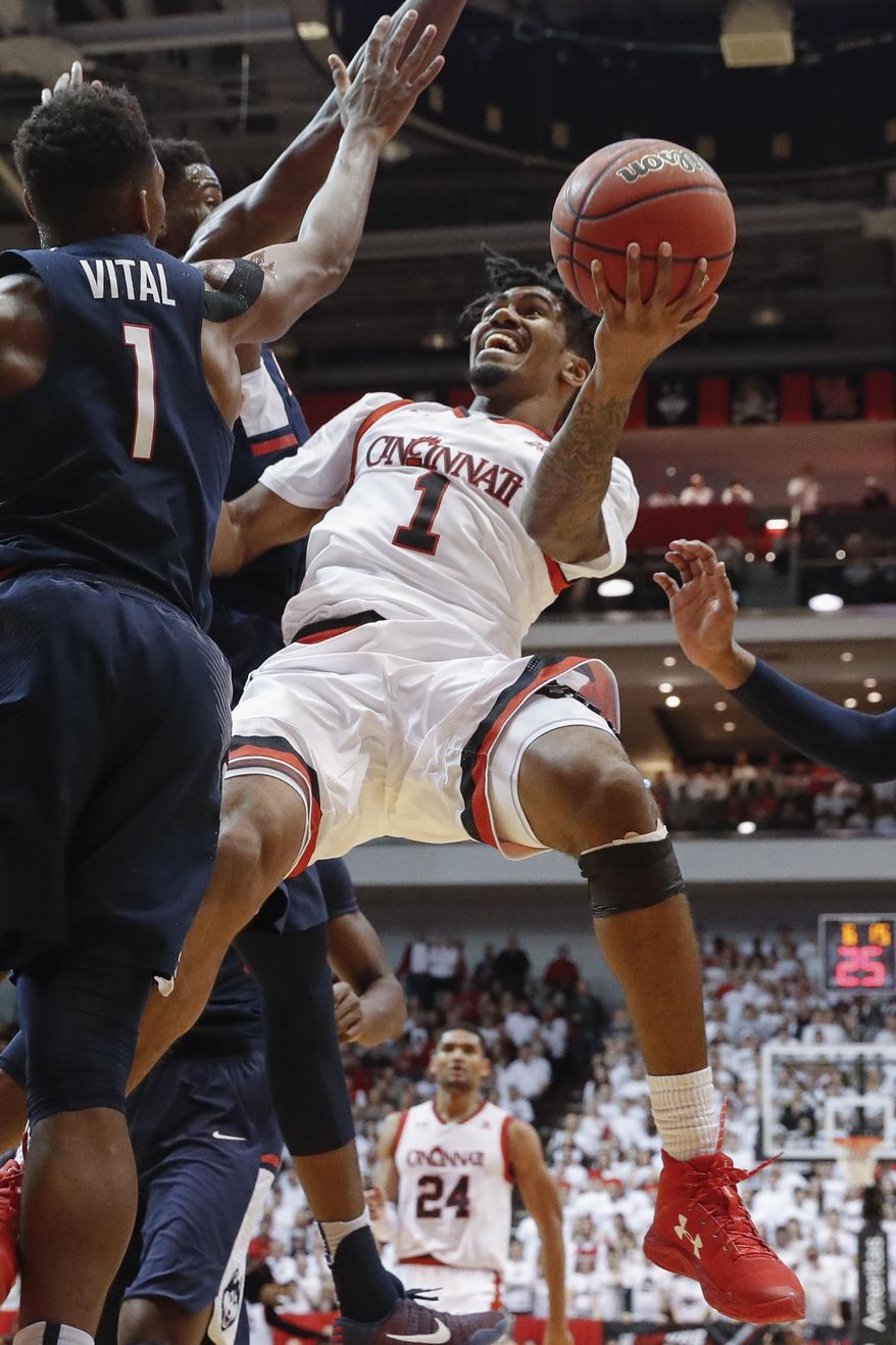 Cincinnati's Jacob Evans (1) shoots against Connecticut's Christian Vital (1) in the first half of an NCAA college basketball game, Saturday, Feb. 4, 2017, in Cincinnati. (AP Photo/John Minchillo)