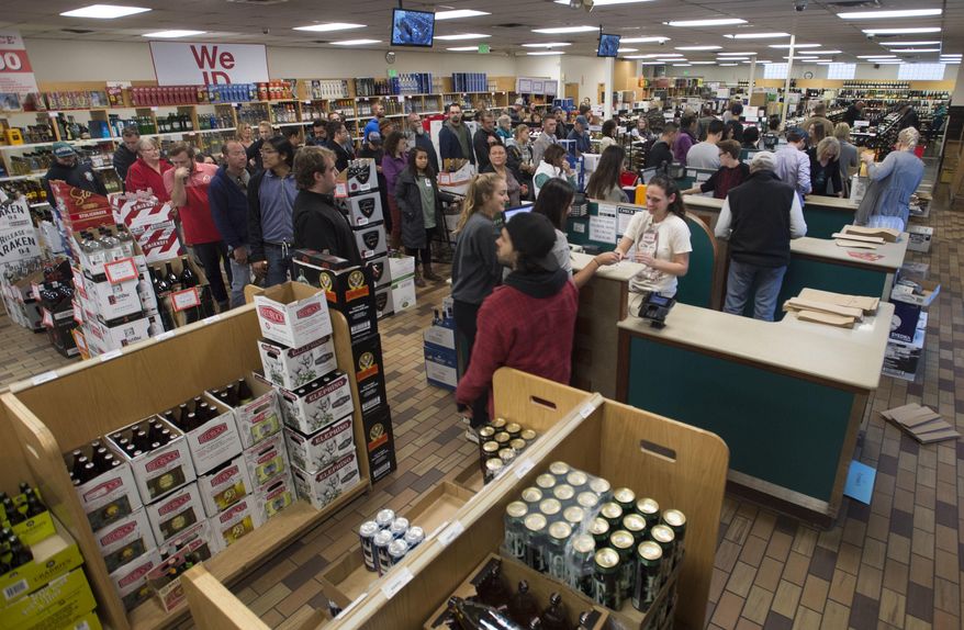 In this Wednesday, Nov. 23, 2016, photo, shoppers form lines at the Sugarhouse State Liquor store in Salt Lake City. A mobile app that would give tourists directions to the nearest Utah liquor store or let consumers know if their favorite brand of bourbon was in stock doesn't seem that far-fetched in a world where people carry cell phones everywhere. Liquor Commissioner Olivia Agraz has asked Utah Department of Alcoholic Beverage Control staff to investigate the costs of creating a DABC mobile app. Her request was prompted by a recent trip to Texas, where the state liquor department has developed consumer-friendly technology. (Steve Griffin/The Salt Lake Tribune via AP)