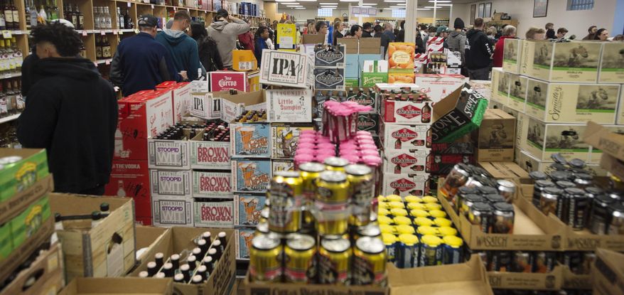 In this Wednesday, Nov. 23, 2016, photo, shoppers form lines at the Sugarhouse State Liquor store in Salt Lake City. A mobile app that would give tourists directions to the nearest Utah liquor store or let consumers know if their favorite brand of bourbon was in stock doesn't seem that far-fetched in a world where people carry cell phones everywhere. Liquor Commissioner Olivia Agraz has asked Utah Department of Alcoholic Beverage Control staff to investigate the costs of creating a DABC mobile app. Her request was prompted by a recent trip to Texas, where the state liquor department has developed consumer-friendly technology. (Steve Griffin/The Salt Lake Tribune via AP)