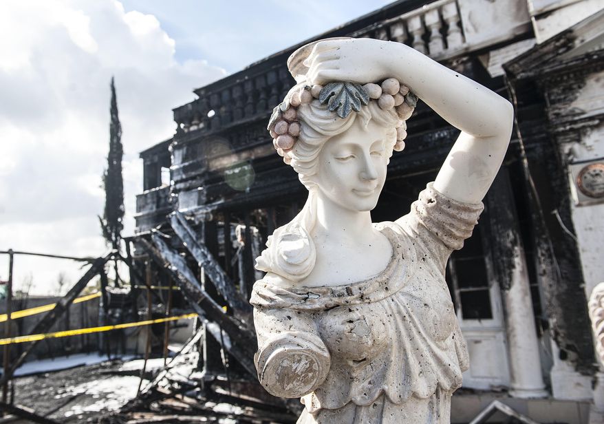 A statue stands among the devastation after an overnight blaze destroyed the Anaheim White House restaurant on Saturday, Feb. 4, 2017. (Nick Agro/Orange County Register via AP)