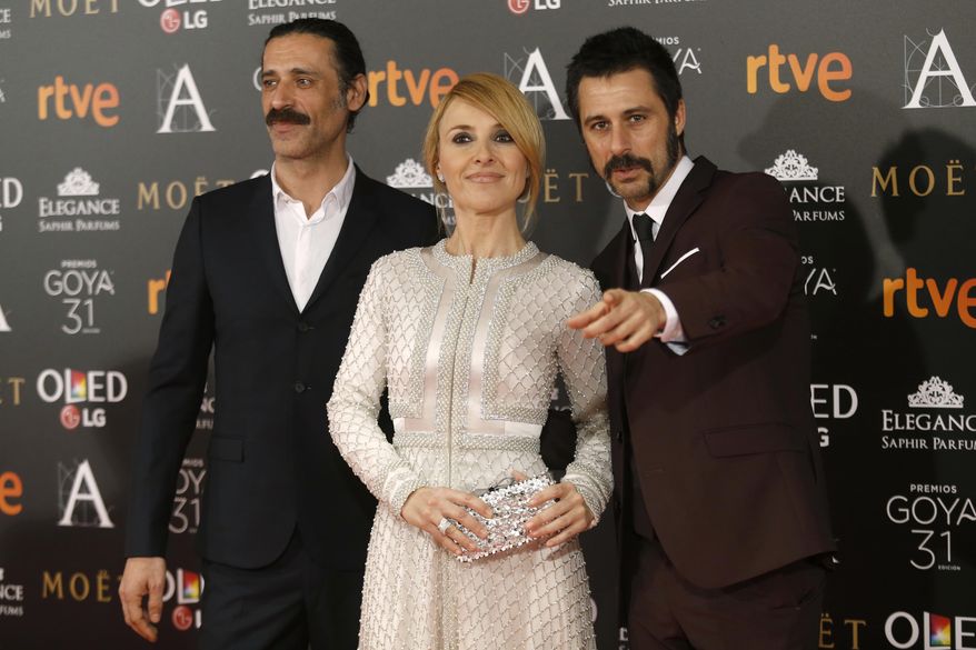 Spanish actress Cayetana Guillen Cuervo, center, and actors, Nacho Fresneda, left, Hugo Silva, pose for photographers before the Goya Film Awards Ceremony in Madrid, Saturday, Feb. 4, 2017. The Goya Awards are Spain's main national annual film awards. (AP Photo/Francisco Seco)