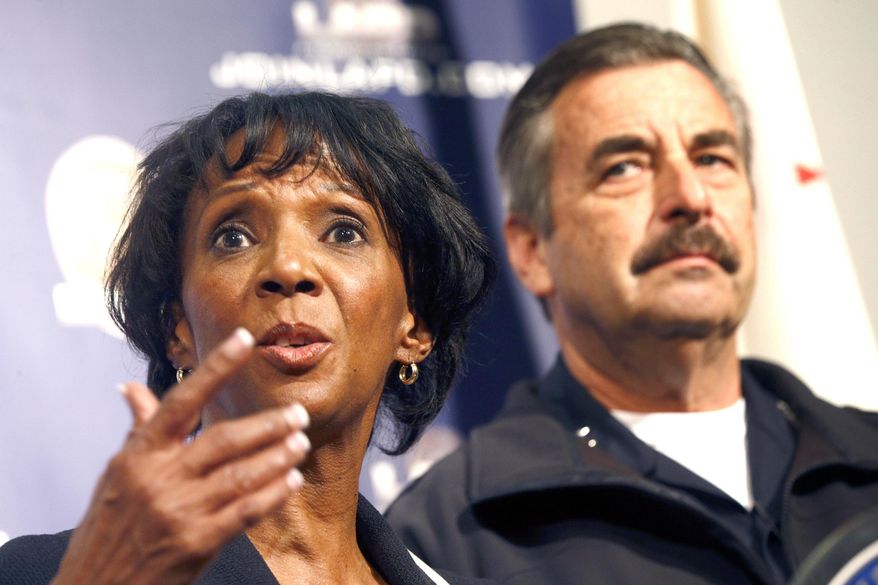Los Angeles District Attorney Jackie Lacey, left, talks while Los Angeles Police Chief Charlie Beck looks on during a news conference in Los Angeles, Monday, Feb. 6, 2017. Los Angeles police say three people are in custody and a fourth is being sought in connection with a deadly fire that struck an apartment building in 1993. Two men were arrested Feb. 3 and a woman was already in custody in connection with the fire. Police will ask the district attorney to file homicide charges with special circumstances involving multiple victims, gang affiliations and arson. (AP Photo/Nick Ut)