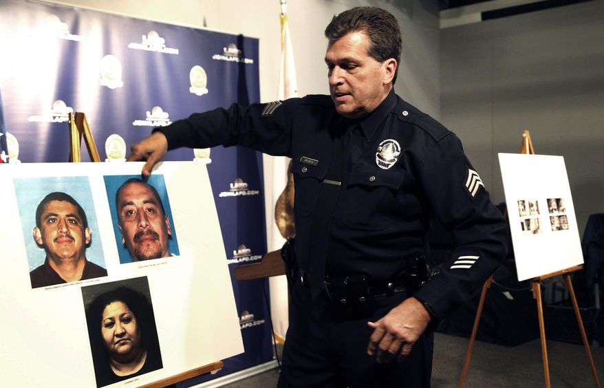 Los Angeles police Sgt. Jack Richter displays photos of arson suspects from a 1993 fire prior to a news conference in Los Angeles, Monday, Feb. 6, 2017. Los Angeles police say three people are in custody and a fourth is being sought in connection with a deadly fire that struck an apartment building in 1993. Two men were arrested Feb. 3 and a woman was already in custody in connection with the fire. Police will ask the district attorney to file homicide charges with special circumstances involving multiple victims, gang affiliations and arson. (AP Photo/Nick Ut)