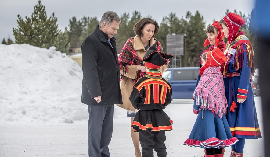 Local young Sami people welcome Finnish President Sauli Niinisto, left, and his wife Jenni Haukio in front of the Sami Museum Siida in Inari, Finnish Lapland, Monday Feb. 6, 2017. The indigenous people of Europe's Arctic north, formerly nomadic reindeer herders in Lapland, are celebrating their national day with hundreds of events across Nordic lands. (Otto Ponto/Lehtikuva via AP)