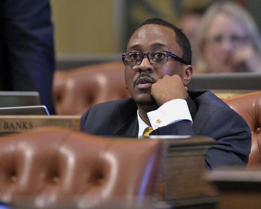 In this May 21, 2013, photo, Michigan Rep. Brian Banks sits at his desk on the floor of the House of Representatives at the Capitol in Lansing, Mich. Banks, a Michigan lawmaker with a lengthy criminal record, resigned from office Monday, Feb. 6, 2017, as part of a plea deal to resolve charges that he submitted fraudulent pay stubs to secure a $3,000 loan in 2010. (Dale G. Young/Detroit News via AP)