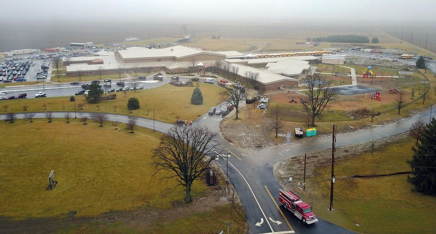 FILE- In this Jan. 20, 2017, file photo authorities investigate the scene after a shooting at West Liberty-Salem Schools in Champaign County, Ohio. The 16-year-old victim of the Ohio school shooting has returned home after several days in the hospital as a court case continues against the suspect. Ryan Cole, the father of victim Logan Cole, said in a Facebook post Saturday, Feb. 4, that Logan was home. (Eric Dietrich/Dayton Daily News via AP, File)