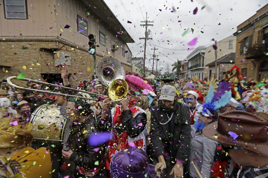 FILE - In this Feb. 17, 2015, file photo, revelers play brass band music as they begin the march of the Society of Saint Anne Mardi Gras parade, on Mardi Gras in New Orleans. New Orleans is entering the height of its annual pre-Lenten Carnival season, culminating on Mardi Gras, or Fat Tuesday, which falls on Feb. 28 this year. Travelers to the city face an abundance of choices on how, when and where to take it all in. (AP Photo/Gerald Herbert, File)