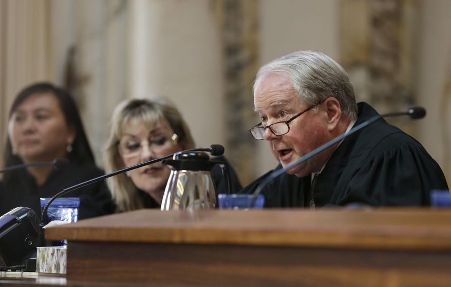 FILE- In this Sept. 18, 2014, file photo, Circuit Judge William A. Fletcher, right, questions Asst. U.S. Atty. Merry Chan about Barry Bonds' conviction before an 11-judge panel of the 9th U.S. Circuit Court of Appeals in San Francisco. The federal appellate court is hearing arguments whether to reinstate President Donald Trump's immigration travel ban. (AP Photo/Eric Risberg, Pool, File)