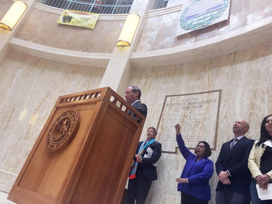 Sen. Tom Udall, D-New Mexico, left, speaks to immigrant rights advocates at the New Mexico Statehouse in Santa Fe, N.M., Monday, Feb. 6, 2017, while state Rep. Patricia Roybal Caballero, D-Albuquerque, third from right, throws her fist in the air. Udall told advocates on Monday that President Donald Trump's travel ban on seven Muslim-majority countries is "illegal and unconstitutional" and vowed to fight it with other Democratic senators. (AP Photo/Russell Contreras)