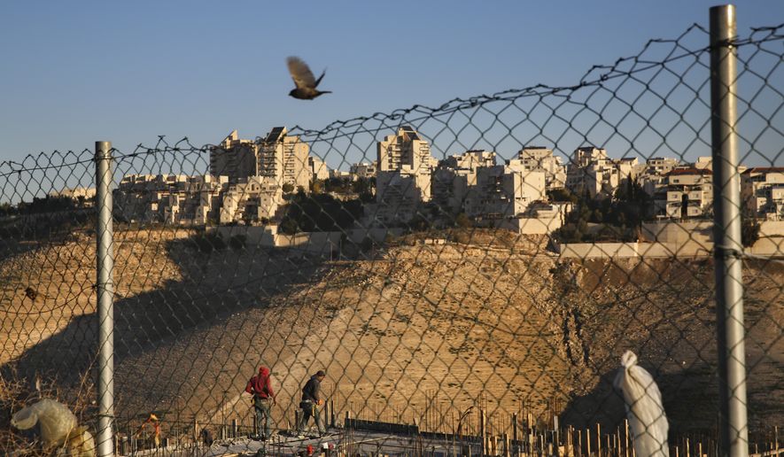Palestinian laborers work at a construction site in a new housing project in the Israeli settlement of Maale Adumim, near Jerusalem, Tuesday, Feb. 7, 2017. A Palestinian Cabinet minister on Tuesday called on the international community to punish Israel for a contentious new law, just hours after the Israeli parliament adopted the bill to retroactively legalize thousands of West Bank settlement homes built unlawfully on private Palestinian land.(AP Photo/Oded Balilty)