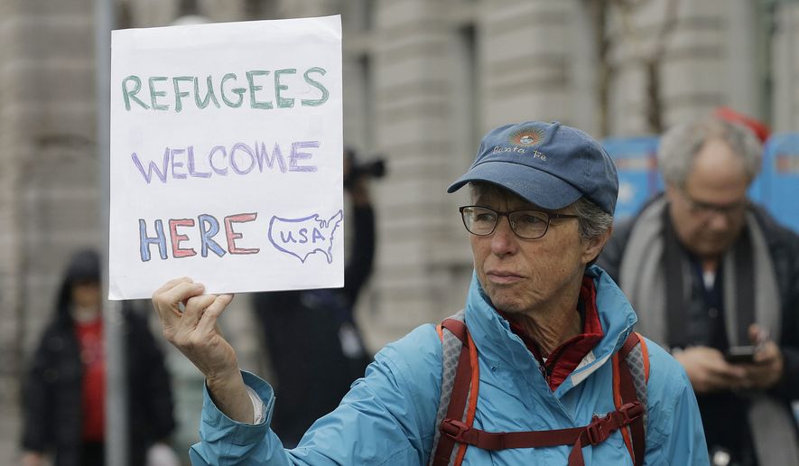 Ann Carey holds up a sign outside of the 9th U.S. Circuit Court of Appeals in San Francisco, Tuesday, Feb. 7, 2017. President Donald Trump&#39;s travel ban faced its biggest legal test yet Tuesday as a panel of federal judges prepared to hear arguments from the administration and its opponents about two fundamentally divergent views of the executive branch and the court system. (AP Photo/Jeff Chiu)