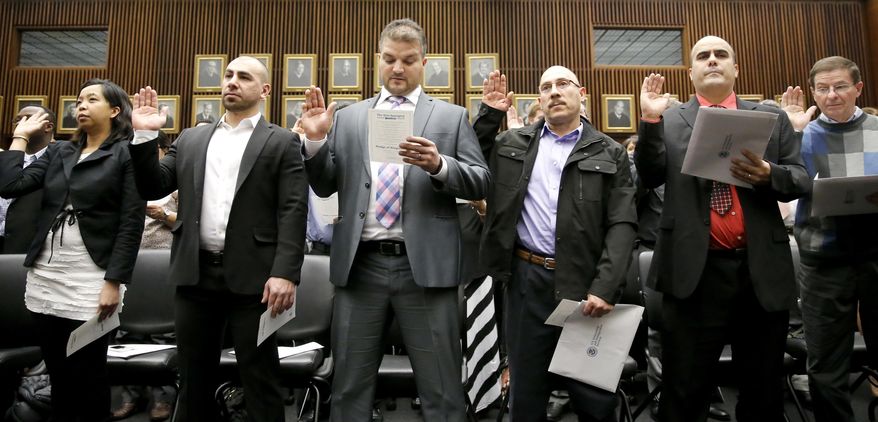 Many of the 117 immigrants from 37 countries take the oath of citizenship from U.S. District Judge Sara Ellis, in the Northern District of Illinois, during a naturalization ceremony Tuesday, Feb. 7, 2017, in Chicago. (AP Photo/Charles Rex Arbogast)