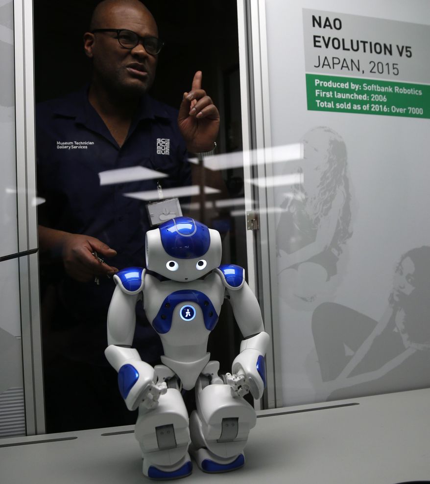 A technician adjusts Nao Evolution robot from Japan, during a press preview for the Robots exhibition held at the Science Museum in London, Tuesday, Feb. 7, 2017. The exhibition which shows 500 years of mechanical and robotic advances is open to the public form Feb. 8 through to Sept. 3. (AP Photo/Alastair Grant)