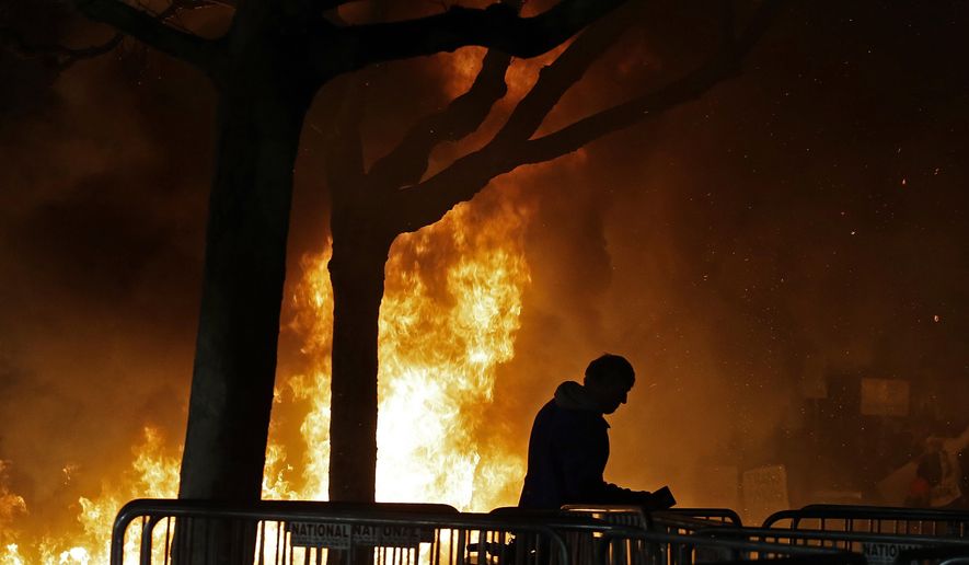 In this Feb. 1, 2017, file photo, a fire set by demonstrators protesting a scheduled speaking appearance by Breitbart News editor Milo Yiannopoulos burns on Sproul Plaza on the University of California, Berkeley campus. (AP Photo/Ben Margot, File)