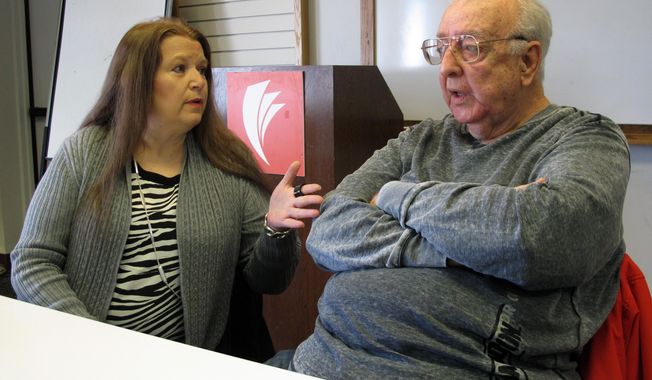 In this Monday, Jan. 30, 2017, photo, Lori Cooper, left, discusses her efforts to bring to trial the suspect who shot her father, Columbus police officer Niki Cooper, in 1972, as Niki Cooper and partner Bob Stout, right, interrupted a burglary,  in Columbus, Ohio. After her father’s death three years earlier, Lori Cooper discovered the 82-year-old suspect was alive and living in Dayton, Ohio, about an hour away. (AP Photo/Andrew Welsh-Huggins)