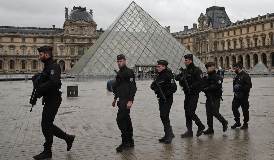 Armed police officers patrol in the courtyard of the Louvre museum near where a soldier opened fire after he was attacked in Paris, Friday, Feb. 3, 2017. A knife-wielding man shouting "Allahu akbar" attacked French soldiers on patrol near the Louvre Museum Friday in what officials described as a suspected terror attack. The soldiers first tried to fight off the attacker and then opened fire, shooting him five times. (AP Photo/Christophe Ena)