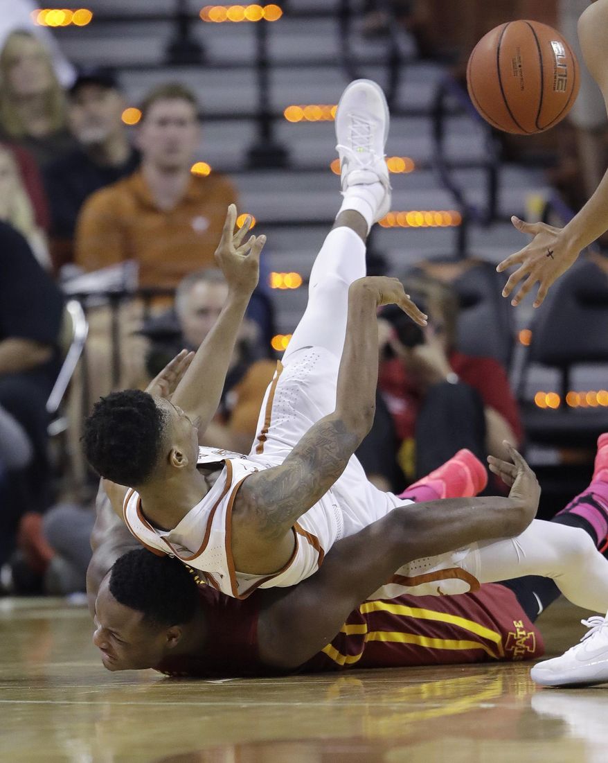 Texas guard Kerwin Roach Jr., top, passes the ball as he falls on Iowa State guard Deonte Burton (30) during the second half of an NCAA college basketball game, Tuesday, Feb. 7, 2017, in Texas, Texas. Texas won 67-65. (AP Photo/Eric Gay)