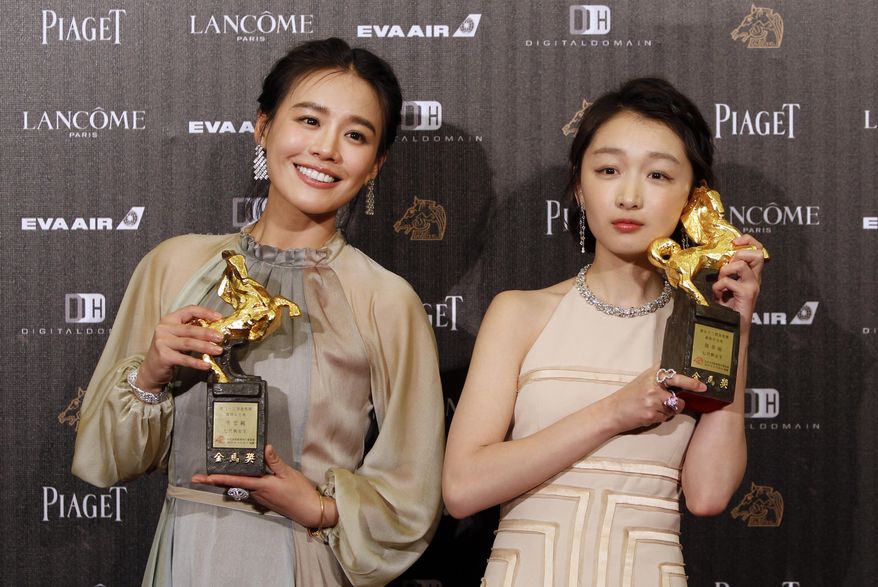 FILE - In this Saturday, Nov. 26, 2016, file photo, Chinese actress Zhou Dongyu, right, and Ma Sichun hold their award for Best Leading Actress at the 53rd Golden Horse Awards in Taipei, Taiwan. Romance drama “Soul Mate” has charmed the Hong Kong Film Awards. The coming-of-age tale of two girls falling for the same boy received 12 nominations, with Zhou and Ma both getting nods in the best actress category. The awards ceremony is on April 9. (AP Photo/Billy Dai)