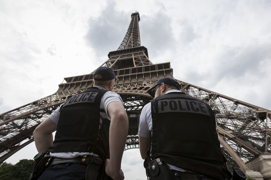 French riot police officers patrol under the Eiffel Tower, near the entrance of the soccer fan zone, prior to the Euro 2016 Group A soccer match between France and Romania, in Paris, June 10, 2016. (Associated Press) ** FILE **