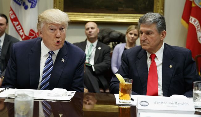 In this file photo, Sen. Joe Manchin, D-W.Va., listens at right as President Donald Trump speaks during a meeting with Senators on his Supreme Court Justice nominee Neil Gorsuch, Thursday, Feb. 9, 2017, in the Roosevelt Room of the White House in Washington. (AP Photo/Evan Vucci) **FILE**