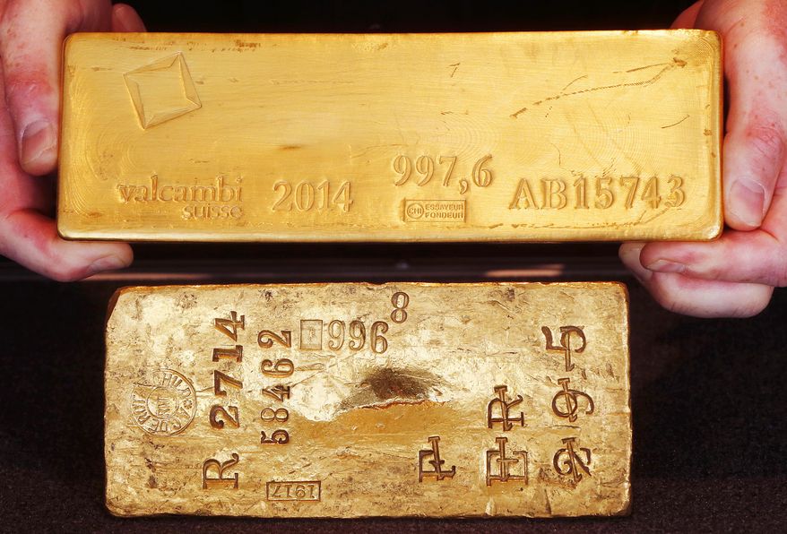 The oldest gold bar of the German Bundesbank from the year 1917 with a value of 442,000 Euros, (US $472,700), bottom, and a bar from 2014 with the same value are displayed in the bank's headquarter Frankfurt, Germany, Thursday, Feb. 9, 2017. Germany's central bank has completed an effort to bring home 300 tons of gold stashed in the United States, part of a plan to repatriate gold bars kept abroad during the Cold War. (AP Photo/Michael Probst)