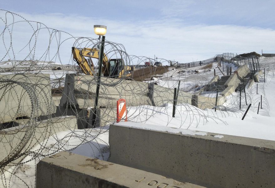 Razor wire and concrete barriers protect access to the Dakota Access pipeline drilling site Thursday, Feb. 9, 2017 near Cannon Ball, North Dakota. The developer says construction of the Dakota Access pipeline under a North Dakota reservoir has begun and that the full pipeline should be operational within three months. One of two tribes who say the pipeline threatens their water supply on Thursday filed a legal challenge asking a court to block construction while an earlier lawsuit against the pipeline proceeds. (AP Photo/James MacPherson)
