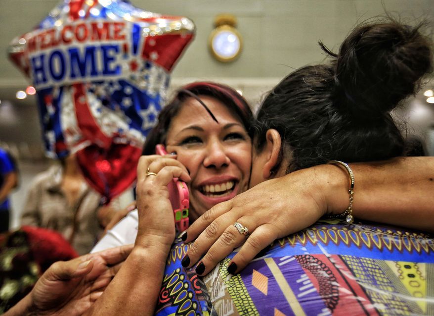 In a Monday, Feb. 6, 2017 photo, Cuban health worker Veidy Diaz, center, is greeted by family and friends as she talks on the phone after finally leaving the immigration and customs section of Miami International Airport. She was part of the group of Cuban health workers that traveled from Colombia after being allowed entry to the United States. She and other Cuban doctors arriving in Miami this week under the Cuban Medical Professionals Parole said they’re relieved to be arriving, during an uncertain time for immigrants to the U.S. under President Donald Trump, but concerned about colleagues left behind. (Carl Juste/Miami Herald via AP)