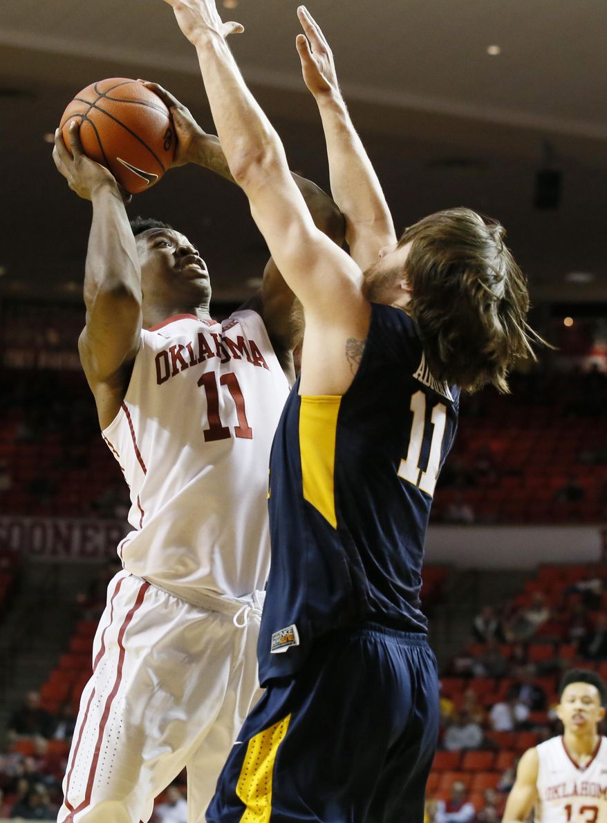 Oklahoma forward Kristian Doolittle (11) shoots in front of West Virginia forward Nathan Adrian (11) during the second half of an NCAA college basketball game in Norman, Okla., Wednesday, Feb. 8, 2017. West Virginia won 61-50. (AP Photo/Sue Ogrocki)
