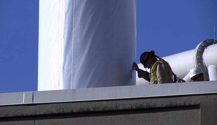 Workers guide a section of the panoramic painting depicting the Battle of Atlanta from the American Civil War as a crane lifts it through the roof at Grant Park in Atlanta, Friday, Feb. 10, 2017. Historians hailed the delicate, painstaking move as a milestone for the 6-ton Cyclorama — one of the world's largest paintings — which was being moved in two sections from the city's Grant Park to the Atlanta History Center. (AP Photo/Alex Sanz)