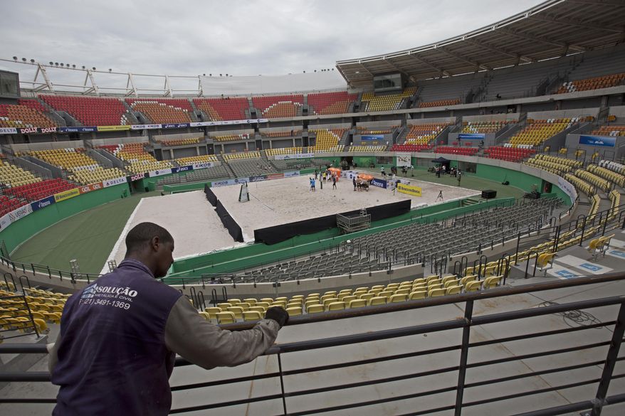 In this Feb. 4, 2017 photo, a worker paints a fence at the Olympic Tennis Center inside Olympic Park in Rio de Janeiro, Brazil. This venue is one of four permanent arenas being run by the federal government, and was used for a one-day beach volleyball tournament, in a city with endless sand and beaches. (AP Photo/Silvia Izquierdo)