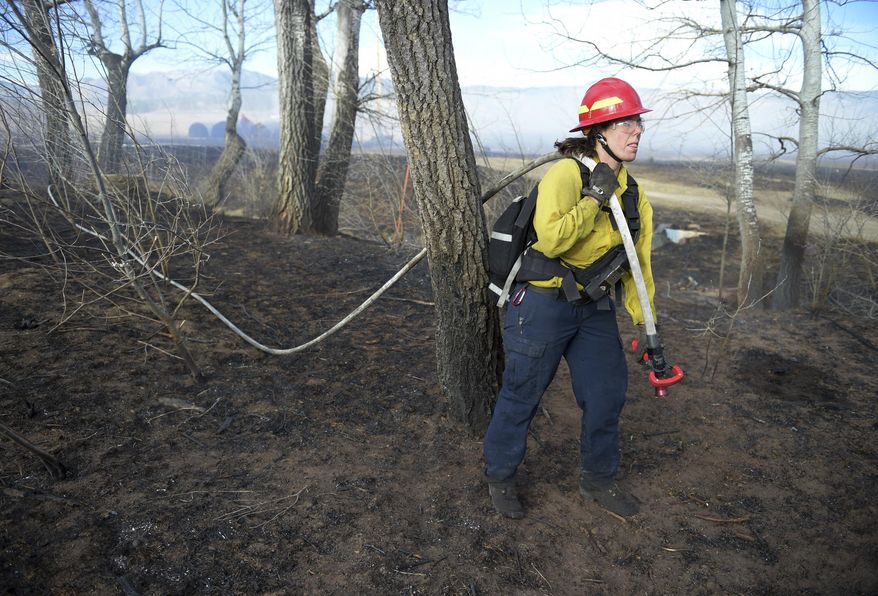 Lyons firefighter Emily Gubler looks for hot spots at Frog Belly Farm, 5255 W. Rogers Rd., west of Longmont, Colo., Friday, Feb. 10, 2017. (Lewis Geyer/The Daily Times Call via AP)
