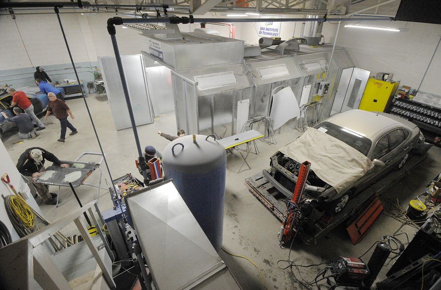 In this Feb. 1, 2017 photo, Students work inside the Erie Institute of Technology auto body technician lab in Erie, Pa. The institute calls the building an auto body technician lab, but it looks, sounds, smells and feels more like a garage. The school sees this building, outfitted with a lift, paint booth and frame-straightening machine, as a place where students can take the first steps toward a new career. (Greg Wohlford/Erie Times-News via AP)