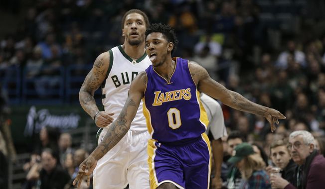 Los Angeles Lakers&#x27; Nick Young (0) reacts after his 3-point basket in front of Milwaukee Bucks&#x27; Michael Beasley during the second half of an NBA basketball game Friday, Feb. 10, 2017, in Milwaukee. (AP Photo/Jeffrey Phelps)