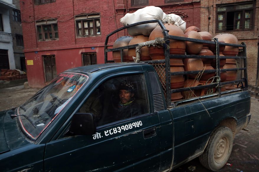 In this Thursday, Jan. 26, 2017 photo, clay pots made by Nepalese Prajapati potters are loaded in a vehicle to be taken for sale in the ancient Nepali town of Thimi. In the past, Prajapati potters would travel across the country to sell their wares. That practice has already died out as more durable material replaced clay pots. Of the nearly 2,000 Prajapati families in town, less than 300 families now depend on clay pottery for a living. (AP Photo/Niranjan Shrestha)