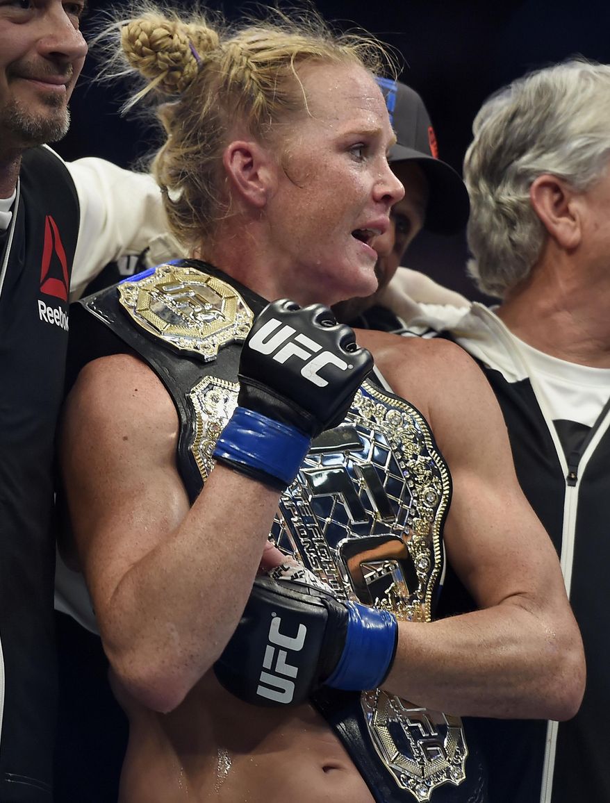 FILE - In this Nov. 15, 2015, file photo, Holly Holm holds the champion belt after defeating Ronda Rousey during their UFC 193 bantamweight title fight in Melbourne, Australia. Her leap from obscurity to instant celebrity landed her on daytime talk shows and chatting with late-night hosts and made her _ oh so briefly _ the most talked about fighter in UFC. (AP Photo/Andy Brownbill, File)