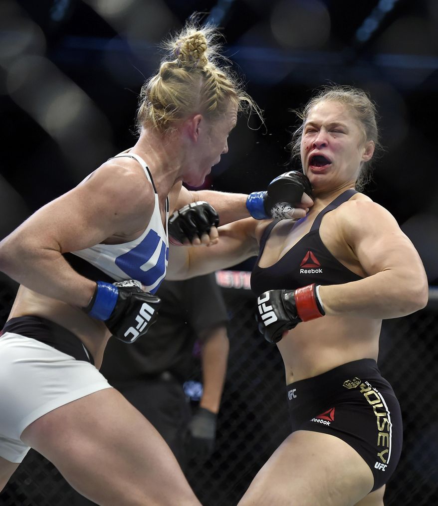 FILE - In this Nov. 15, 2015, file photo, Holly Holm, left, punches Ronda Rousey during their UFC 193 bantamweight mixed martial arts title fight in Melbourne, Australia. Her leap from obscurity to instant celebrity landed her on daytime talk shows and chatting with late-night hosts and made her _ oh so briefly _ the most talked about fighter in UFC. (AP Photo/Andy Brownbill, File)