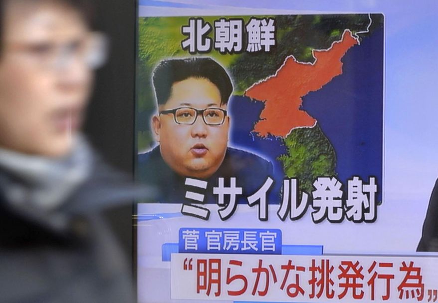 A woman walks past a screen showing a TV news on a missile launch by North Korea with a photo of North Korean leader Kim Jong Un and the map of North Korea in Tokyo, Sunday, Feb. 12, 2017. North Korea reportedly fired a ballistic missile early Sunday in what would be its first such test of the year and an implicit challenge to U.S. President Donald Trump, who stood with the Japanese leader as Shinzo Abe called the move "absolutely intolerable." Details of the launch, including the type of missile, were scant. Letters read: North Korea fired a missile. Chief Cabinet Secretary (Yoshihide) Suga said: "(this is) a clearly provocative act." (Yoshitaka Sugawara/Kyodo News via AP)